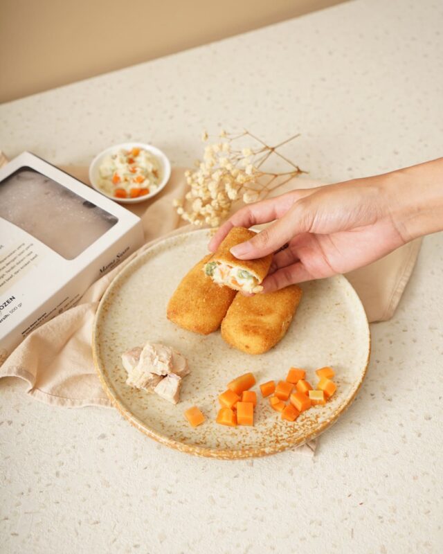 Tangan mengambil Risoles Ragout Ayam dari piring
