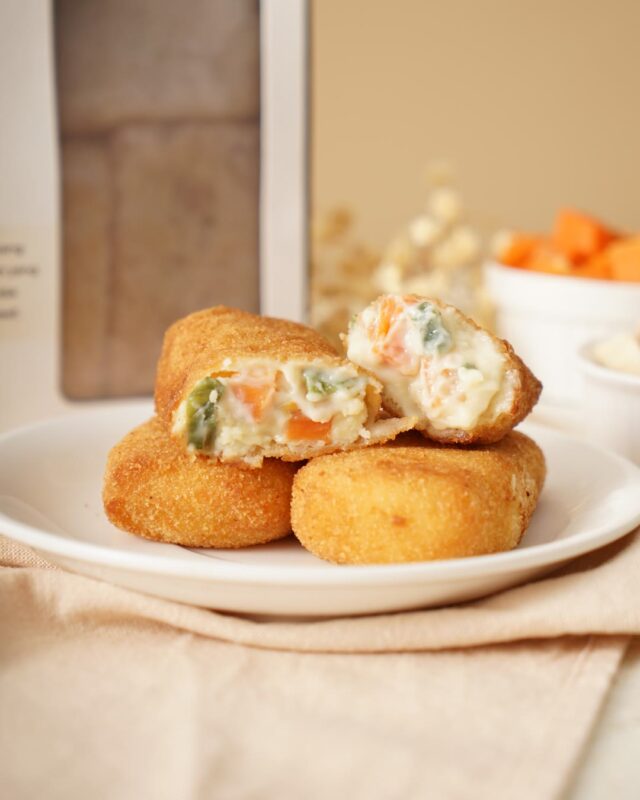 Risoles Ragout Ayam Mama Swan, satu dipotong memperlihatkan isi ragout ayam dan sayur, dengan kotak kemasan